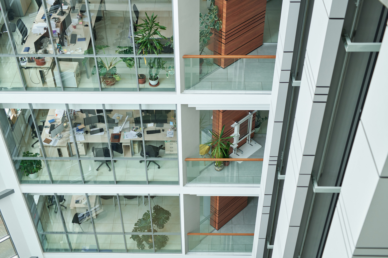 Part of multi-storey building with openspace offices behind large windows